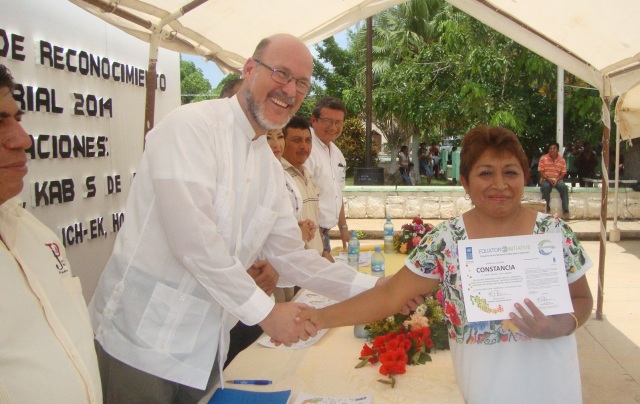 Xavier Moya García, coordinador de uno de los programas del PNUD en el Sureste de México entrega el reconocimiento a la Sra. Leydi Pech